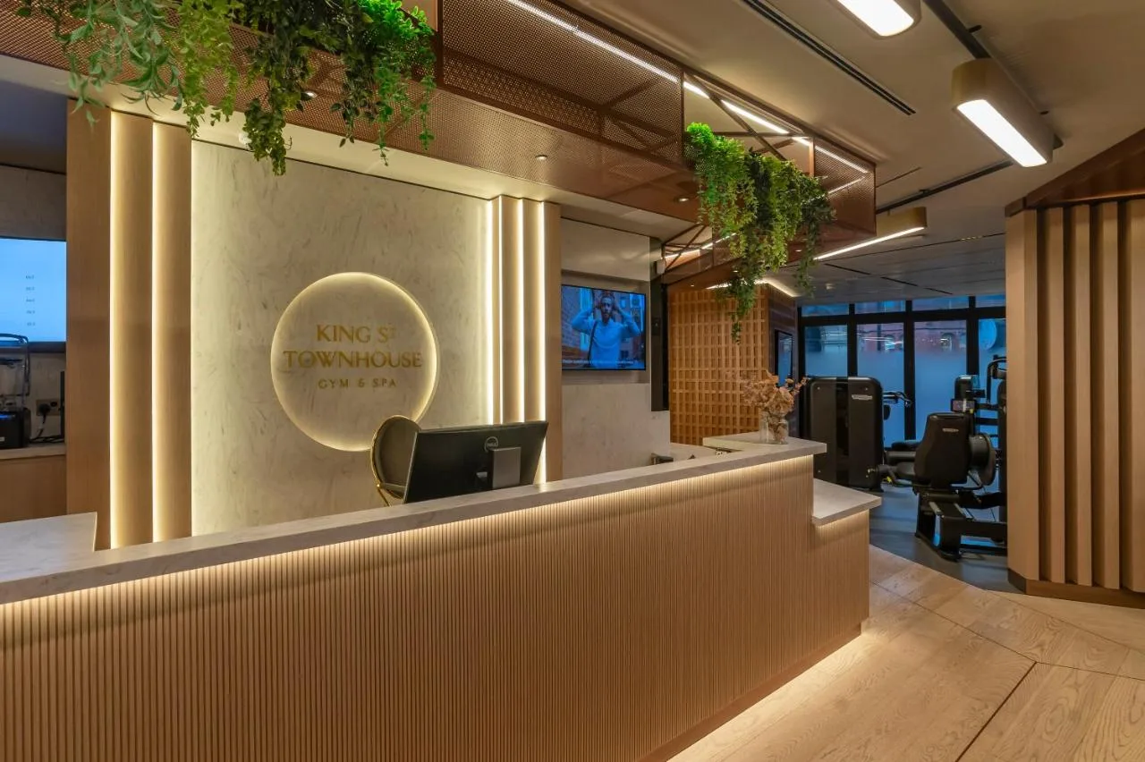 an office with a reception counter with plants on the wall at King Street Townhouse Hotel & Spa in Manchester